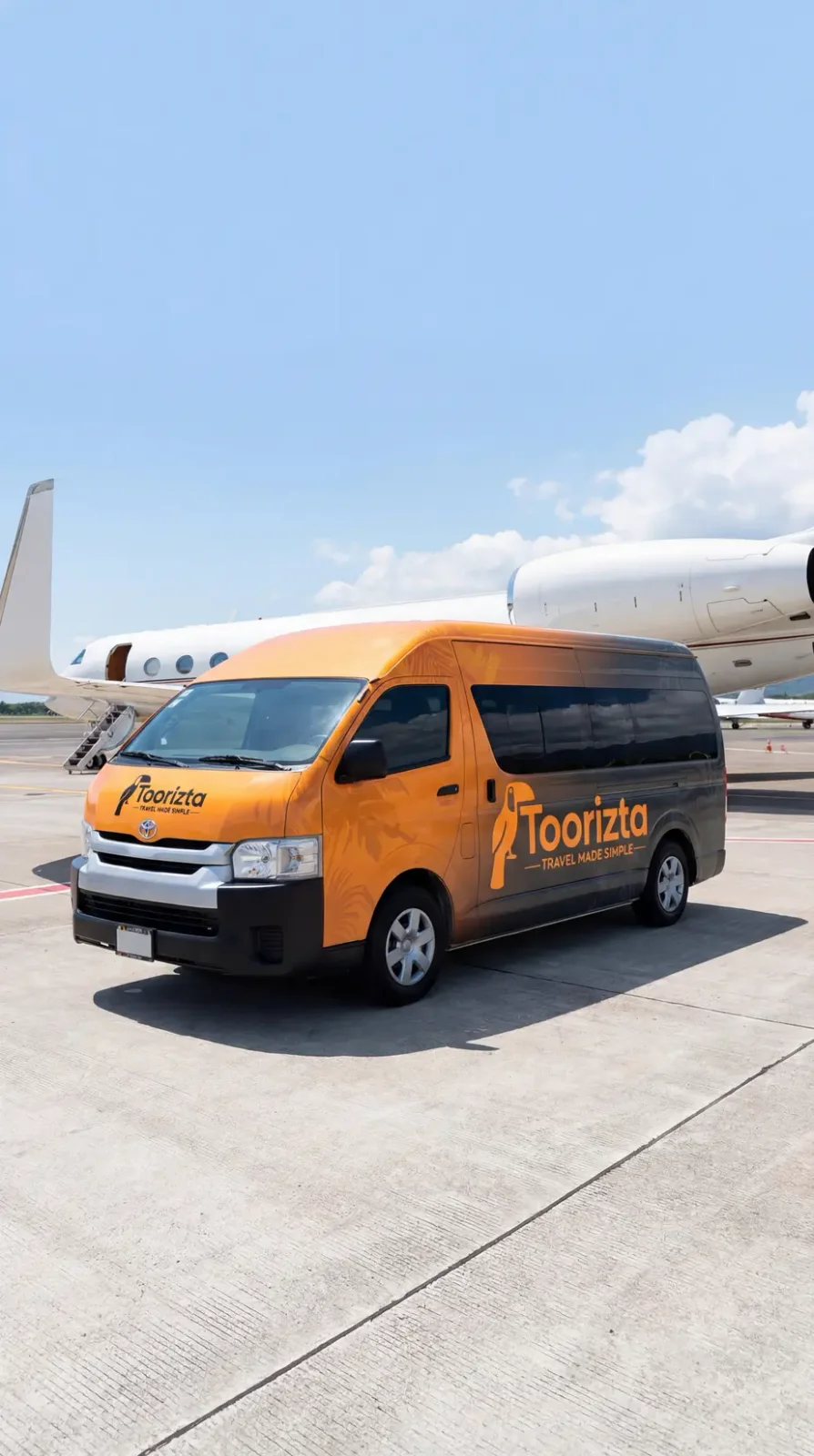 Orange Toorizta shuttle van parked on airport tarmac next to a private jet