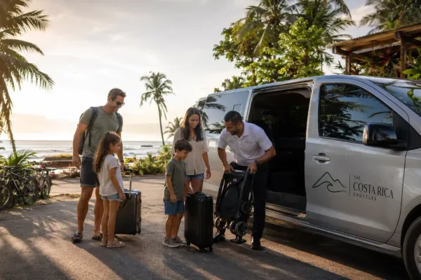 A family with luggage and a stroller boards a Costa Rica Shuttles van near palm trees by the coast