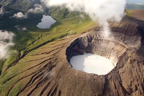 Aerial view of Rincón de la Vieja volcano crater with a turquoise lake and rising steam