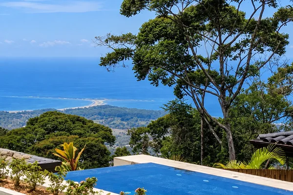 Infinity pool overlooking a tree-covered ridge with ocean and coastline view near Uvita, Costa Rica