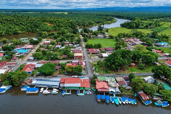 Aerial view of Sierpe village with riverside boats docked along the waterfront and surrounding rainforest