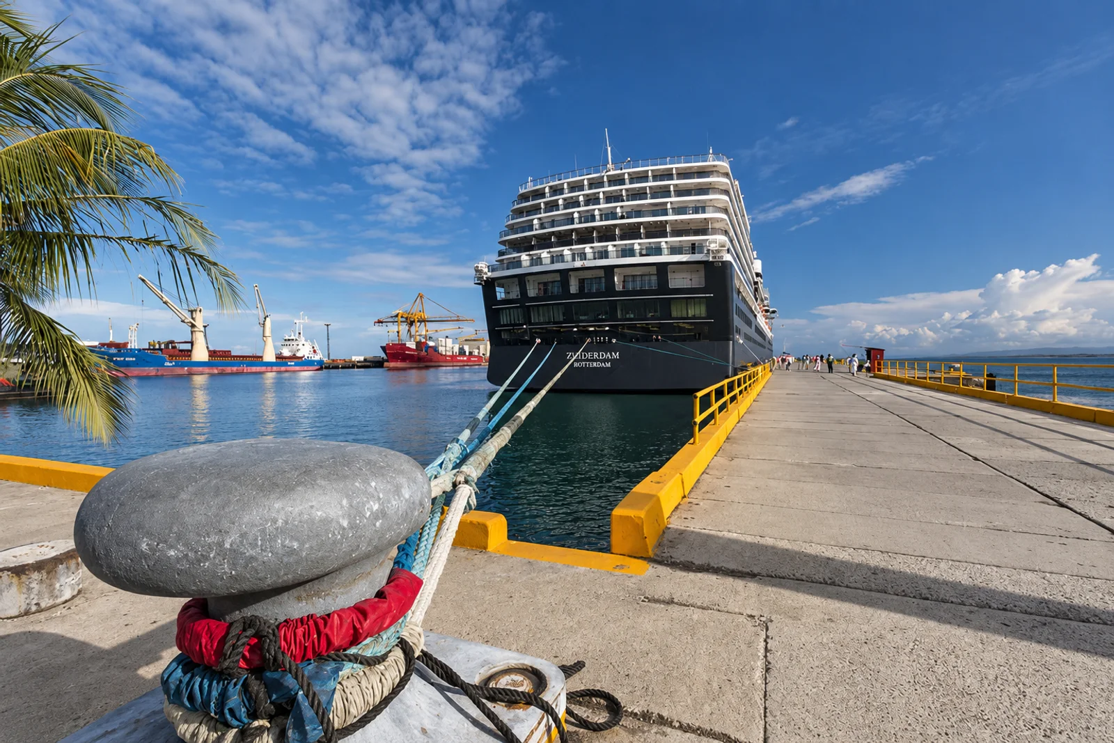 Cruise ship Zuiderdam docked at a pier with a mooring bollard and rope in the foreground, Puerto Limón